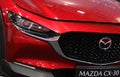 RomaniaÃ¢â¬â2022:Front-side view with logo and head light detail of a new red car Mazda CX 30.